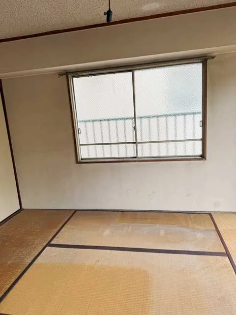 品物を運び出し床と窓まわりが見える片付け後の洋室
